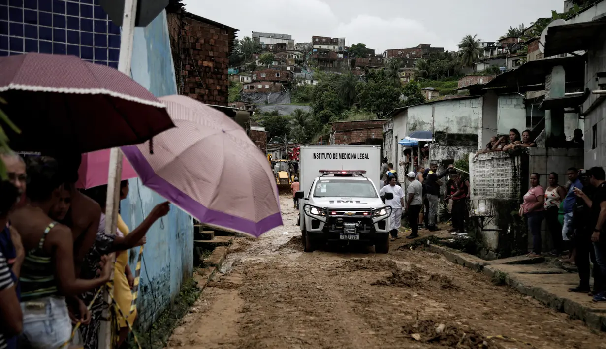 Sebuah kendaraan lembaga forensik membawa jenazah korban setelah tanah longsor di komunitas Jardim Monte Verde, lingkungan Ibura, di Recife, Negara Bagian Pernambuco, Brasil (29/5/2022). Hujan deras yang melanda negara bagian Pernambuco di timur laut Brasil menewaskan 34 orang. (AFP/Brenda Alcantara)