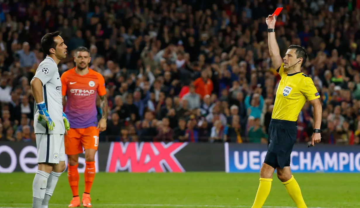Wasit memberikan kartu merah penjaga gawang City, Claudio Bravo setelah sengaja menepis bola di luar kotak penalti, Barcelona, Spanyol (19/10). Bravo digantikan Caballero dan City harus bermain 10 orang. (Reuters/Albert Gea)