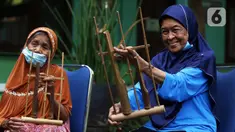 Para lansia mengikuti latihan angklung di Rumah Rehabilitasi Psikososial Dinas Sosial Kota Tangerang, Banten, Rabu (19/5/2021). Kegiatan berlatih angklung bagi lansia tersebut guna mengisi waktu luang sekaligus melatih motorik, auditori, dan sensorik para lansia. (Liputan6.com/Angga Yuniar)