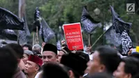 Peserta aksi membawa poster saat berunjuk rasa di Pintu Barat Monas, Jakarta, Selasa (18/7). Terlihat massa memadati pintu Barat Monas dengan membawa atribut aksi spanduk dan bendera. (Liputan6.com/Faizal Fanani)