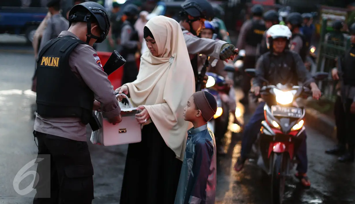 Petugas kepolisian memeriksa tas jemaah di area Masjid Istiqlal, Jakarta, Rabu (6/7). Pengamanan ketat dilakukan untuk mengantisipasi dan membuat rasa aman jemaah dalam melaksanakan salat Idul Fitri 1437 H. (Liputan6.com/Faizal Fanani)