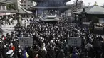 Pengunjung berdoa untuk keberuntungan selama "hatsumode," atau kunjungan pertama mereka tahun ini ke kuil atau kuil, di kuil Buddha Kawasaki Daishi di Kawasaki, dekat Tokyo, Senin (3/1/2022). (AP Photo/Eugene Hoshiko)