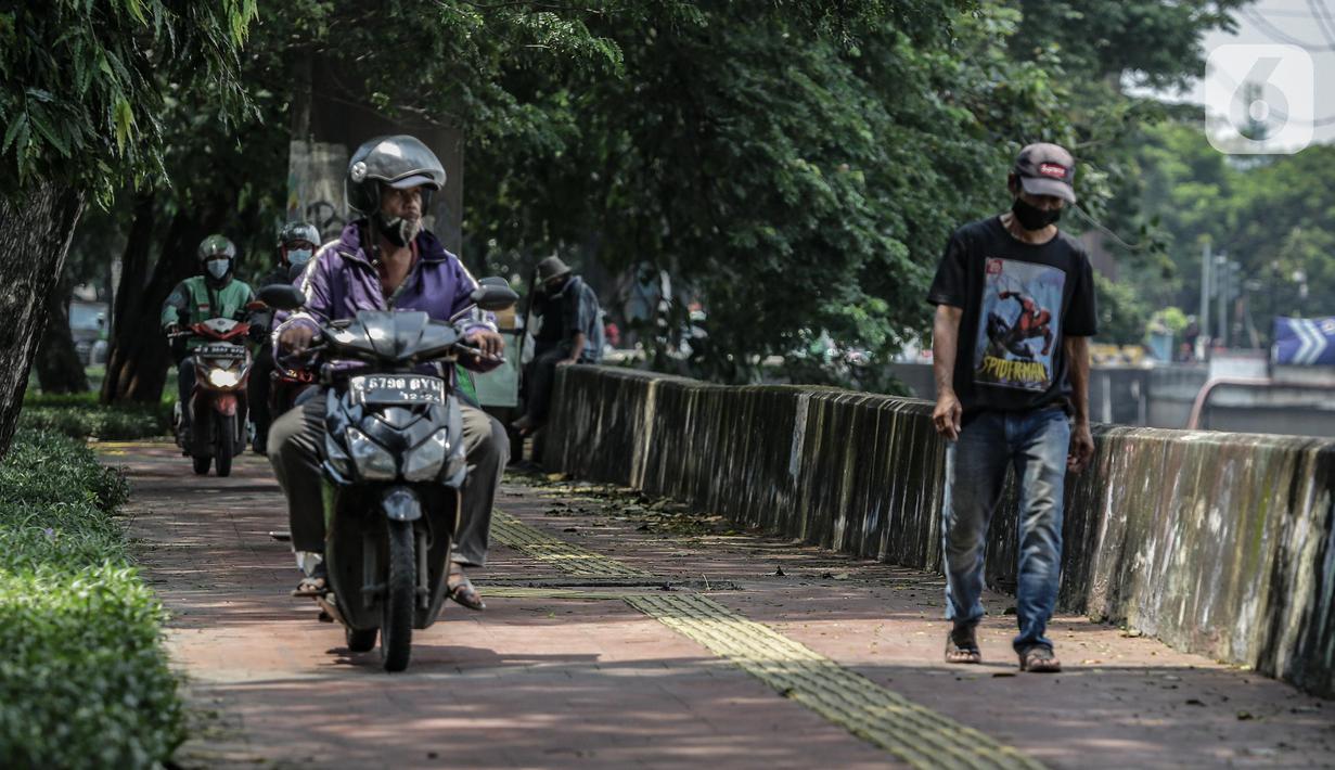 Sejumlah pengendara motor melintas di atas trotoar pejalan kaki di kawasaan Daan Mogot, Jakarta, Senin (26/4/2021). Padatnya volume kendaraan pada jam kerja di kawasan itu membuat sejumlah pengendara motor nekat menggunakan trotoar yang merupakan
hak bagi pejalan kaki. (Liputan6.com/Faizal Fanani)