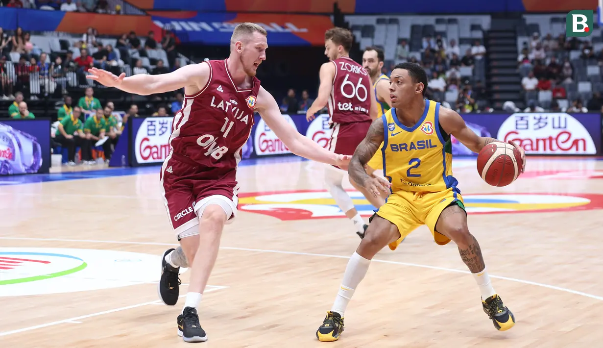 Pebasket Brasil, Yago Santos (kanan) berusaha melewati pebasket Latvia, Rolands Smits pada laga Grup L Piala Dunia FIBA 2023 di Indonesia Arena, Senayan, Jakarta, Minggu (03/09/2023). Latvia menang dengan skor 104-84. (Bola.com/Bagaskara Lazuardi)