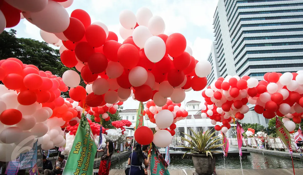 Balon merah putih menghiasi halaman Balai Kota DKI Jakarta, Senin (8/5). Balon tersebut dibawa oleh komunitas Perempuan Peduli Kota Jakarta (PPKJ) dan disebar di seluruh area halaman Balai Kota bercampur dengan karangan bunga. (Liputan6.com/Faizal Fanani)