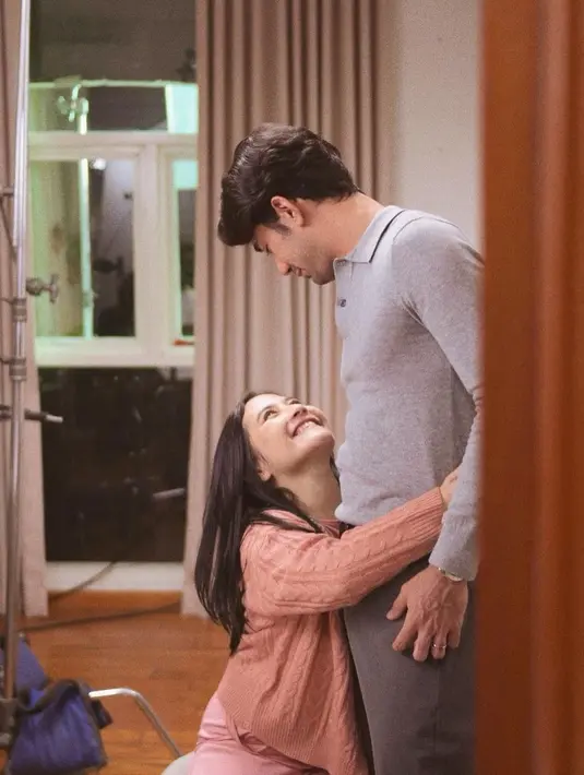Dalam foto lainnya, Prilly terlihat mengenakan sweater oranye sedang memeluk mesra pinggang Reza Rahardian yang mengenakan kemeja polo lengan panjang berwarna abu-abu polos. Foto: Instagram.