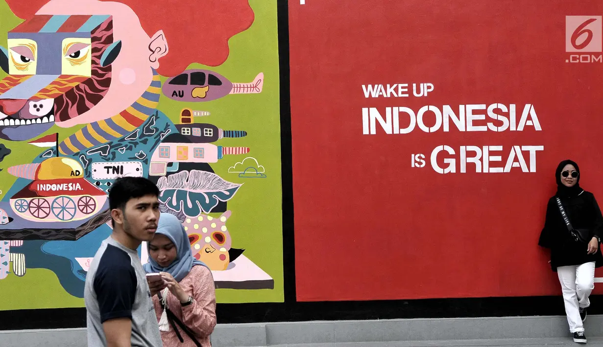 Pengunjung  berpose  di depan mural karya seniman Yogyakarta yang bertajuk INDONESIA IS GREAT, Jakarta, Sabtu (22/7). Pameran ini dalam rangka mewadahi para seniman mural dalam menyuarakan kritik positif maupun negatif. (Liputan6.com/Helmi Afandi)