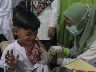 Petugas kesehatan Puskesmas Batu Sari menyuntikan vaksin imunisasi Campak-Rubella (MR) ke murid kelas 1 saat pelaksanaan bulan imunisasi anak sekolah (BIAS) 2025 di SDN Batu Jaya, Kota Tangerang, Banten, Jumat (15/8/2025). (merdeka.com/Arie Basuki)