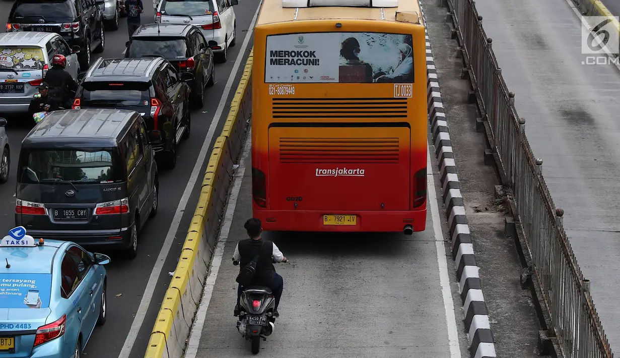 Pengendara sepeda motor berada di belakang bus Transjakarta di Jalan Gunung Sahari, Jakarta, Kamis (27/12). Selain melanggar hukum, perilaku buruk pemotor tersebut juga dapat membahayakan keselamatan. (Liputan6.com/Immanuel Antonius)