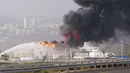 Asap hitam membumbung menyusul kebakaran salah satu tangki kilang minyak di Haifa, utara kota Israel, Minggu (25/12). Petugas pemadam di lokasi mengatakan api tidak menjalar ke tangki bahan bakar yang berada di sekitar kilang minyak. (REUTERS/Baz Ratner)