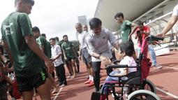 Pelatih Timnas Indonesia U-23, Indra Sjafri, menyapa seorang anak yang datang ke Stadion Madya, Jakarta, Rabu (13/3). Sejumlah anak dari Yayasan Rumah Harapan Indonesia datang menemui Timnas U-23 (Bola.com/Vitalis Yogi Trisna)