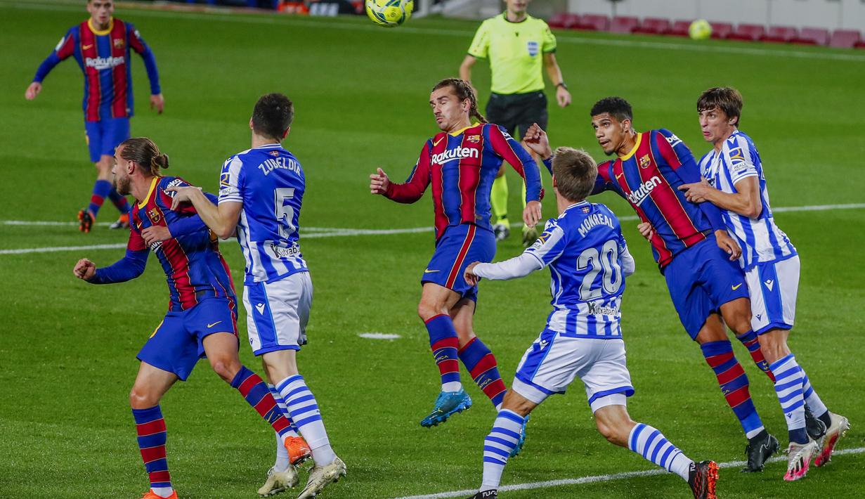Penyerang Barcelona, Antoine Griezmann berusaha menyundul bola saat berhadapan dengan Real Sociedad pada pertandingan La Liga Spanyol di stadion Camp Nou di Barcelona, Spanyol, Kamis (17/12/2020). Aksi Griezmann dengan kepang duanya diselingi dengan performa yang lumayan. (AP Photo/Joan Monfort)