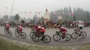 Kabut asap pekat menyelimuti Tugu Ayam di Kabupaten Solok saat lima pebalap Pishgaman Giant Team memimpin dalam Etape 2 Tour de Singkarak 2015, Minggu (4/10/2015). (Bola.com/Arief Bagus)