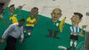 Seorang pejalan kaki melintas di tembok yang telah digambar beberapa tokoh sepakbola, kota Rio de Janeiro, Jumat (9/5/2014) (AFP PHOTO / Vanderlei Almeida).
