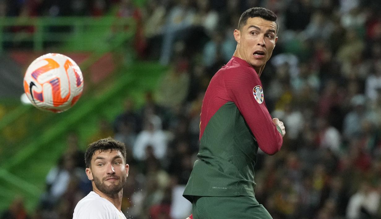 Pemain Timnas Portugal, Cristiano Ronaldo berebut bola dengan pemain Timnas Liechtenstein saat laga Kualifikasi Euro 2024 yang berlangsung di Jose Alvalade, Lisboa, Portugal, Jumat (24/03/2023) dini hari WIB. CR7 berhasil menorehkan rekor baru sebagai pemain dengan torehan caps internasional terbanyak dalam sejarah. Lewat 197 penampilannya bersama Selecao, ia berhasil melewati rekor striker Kuwait, Bader Al-Mutawa yang sebelumnya memimpin dengan 196 caps. (AP Photo/Armando Franca)