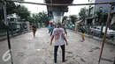Sejumlah remaja bermain sepak bola di kolong rel kereta kawasan Juanda, Jakarta, Jumat (27/5). Tidak tersedianya ruang terbuka menyebabkan lahan tersebut dijadikan tempat bersosialisasi bagi warga. (Liputan6.com/Immanuel Antonius)