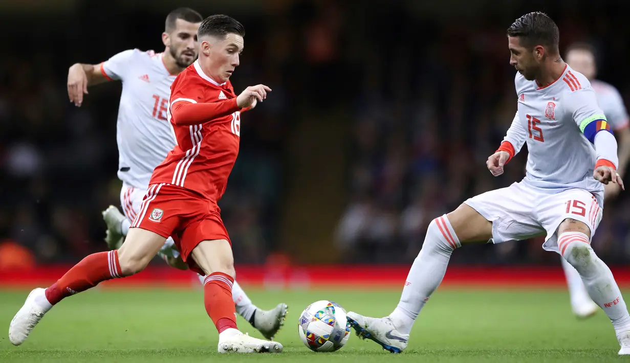 Gelandang Wales, Harry Wilson berusaha melewati bek Spanyol, Sergio Ramos saat bertanding pada uji coba internasional di Stadion Principality, Cardiff, Inggris (11/10). Spanyol menang telak 4-1 atas Wales. (AP Photo/Nick Potts)