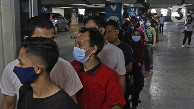 Pedagang saat antre untuk menjalani vaksinasi COVID-19 di Pasar Tanah Abang Blok A, Jakarta, Rabu (17/2/2021). Total sasaran vaksinasi tahap kedua ini mencapai 38.513.446 yang terdiri dari 21 juta lebih lansia, dan hampir 17 juta untuk pekerja pelayanan publik. (Liputan6.com/Herman Zakharia)