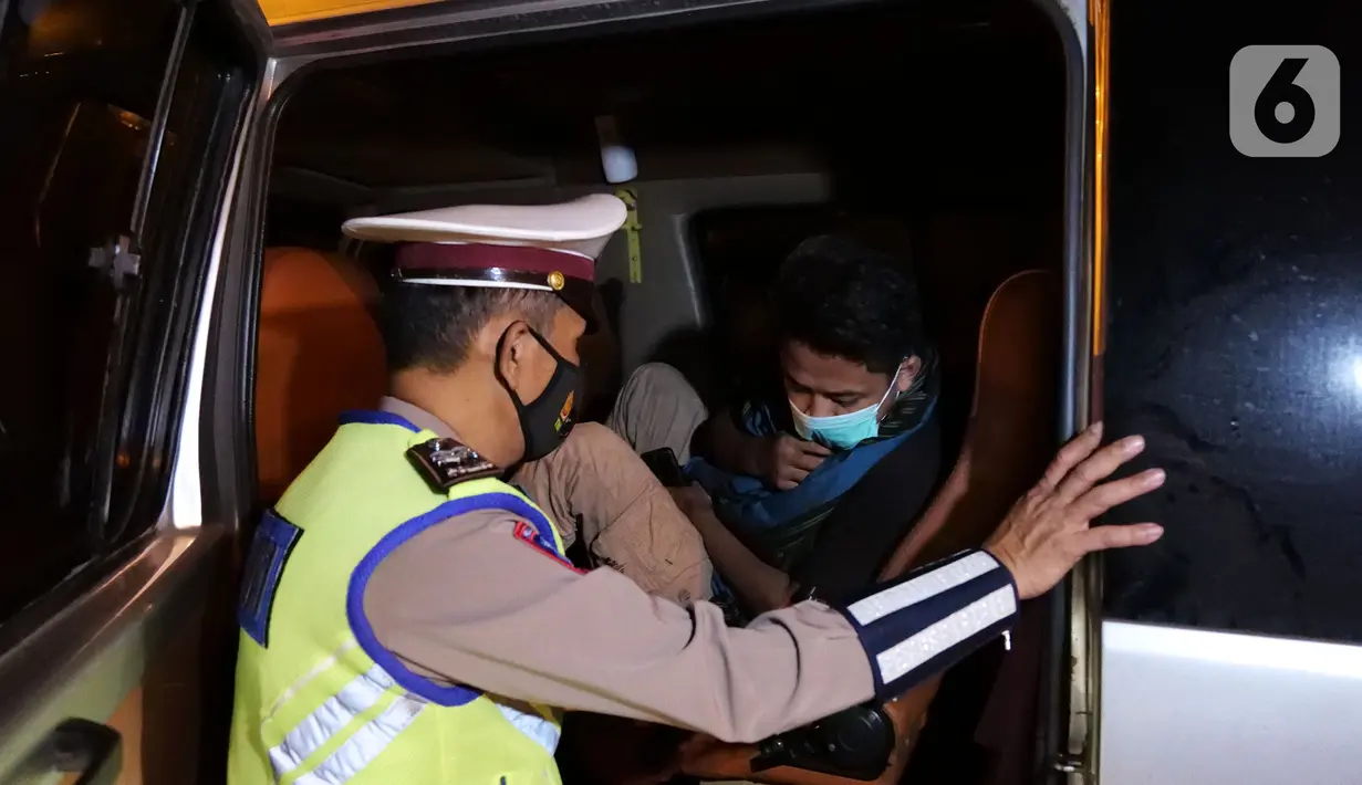 Petugas kepolisian memeriksa dokumen pemudik di Pintu Tol keluar Cikarang Barat, kabupaten Bekasi, Jawa Barat, Kamis (6/5/2021) dini hari. Pemeriksaan sebagai upaya mengantisipasi risiko peningkatan kasus penularan COVID-19 jelang Hari Raya Idul Fitri 1442 H. (Liputan6.com/Herman Zakharia)