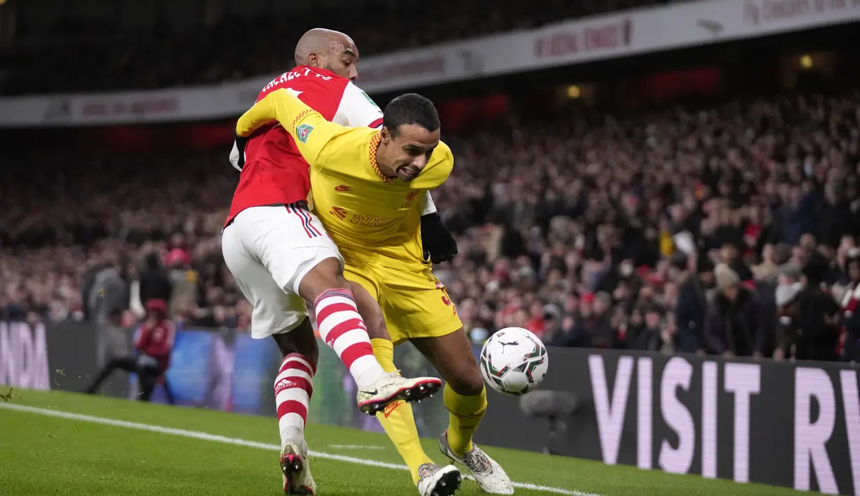 Penyerang Arsenal, Alexandre Lacazette berebut bola dengan bek Liverpool, Joel Matip pada pertandingan leg kedua semifinal Piala Liga Inggris di Stadion Emirates di London, Jumat (21/1/2022). Di final, The Reds akan berhadapan dengan Chelsea. (AP Photo/Matt Dunham)