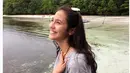 Duduk dipinggir pantai dengan raut wajah begitu ceria. Rambut dibiarkan terurai.  (Bintang.com/@pevpearce)