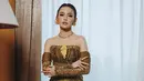 Mahalini Raharja tampil paripurna dengan desain kebaya yang paling beda. Menampilkan strapless top dengan detail korset dan asymetrical ruffle. Dipadukan dengan rok tenun dan gloves brukat yang jadi aksen sabrina [@askyfebrianti]