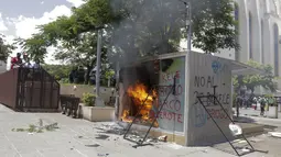 Mesin ATM bitcoin bernama Chivo yang dibakar dalam protes terhadap Presiden Nayib Bukele di San Salvador, El Salvador, Rabu (15/9/2021). Dalam aksi itu ribuan warga Salvador juga memprotes Bukele yang dikhawatirkan kembali mengikuti pemilihan pada tahun 2024 mendatang. (AP Photo/Ivan Manzano)