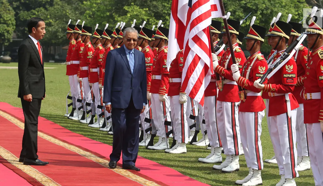 Presiden Jokowi dan PM Malaysia, Mahathir Mohamad memeriksa pasukan kehormatan saat kunjungan kenegaraan di Istana Bogor, Jumat (29/6). Kedua pemimpin akan menggelar pertemuan bilateral membahas berbagai isu dan kerjasama. (Liputan6.com/Angga Yuniar)
