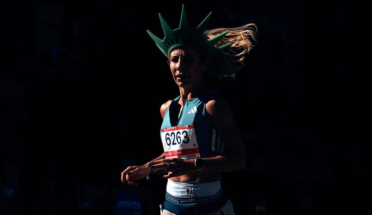 Pelari Prancis, Laura Dufour mengenakan topi menyerupai Patung Liberty saat berkompetisi dalam New York Marathon 2025 pada Minggu (02/11/2025) waktu setempat. (AP Photo/Andres Kudacki)