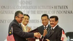 Jaksa Agung RI Basrief Arief (kanan) bertukar dokumen dengan Jaksa Agung Malaysia Tan Sri Abdul Gani Patail (kiri) usai penandatangan kerjasama bidang hukum, Jakarta, Senin (2/4). Perjanjian tersebut berisi kerjasama penegakan hukum, pengurangan kejahatan lintas negara terutama kasus korupsi dan terorisme. (Antara)