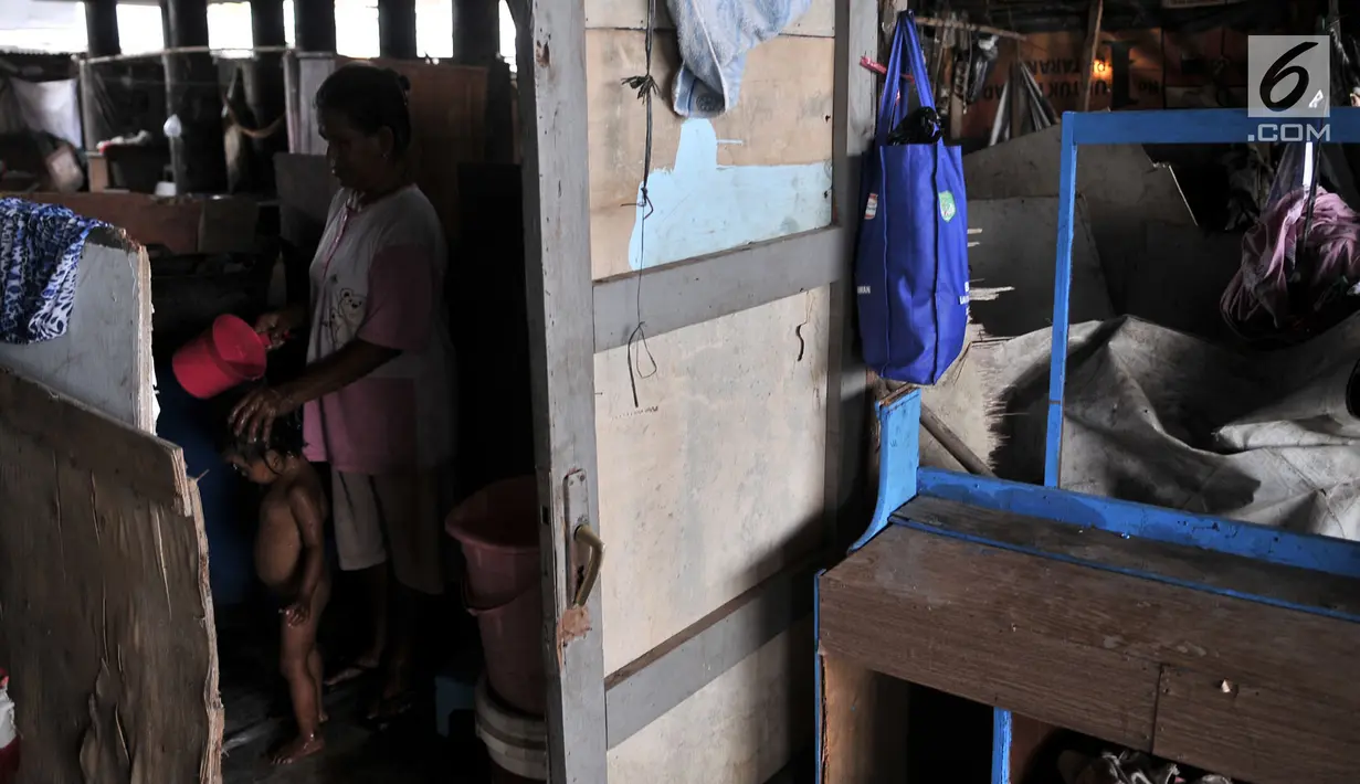 Seorang warga memandikan anaknya di kamar mandi buatan yang berada di permukiman kolong tol kawasan Tanjung Priok, Jakarta, Rabu (16/1).  (Merdeka.com/Iqbal S Nugroho)