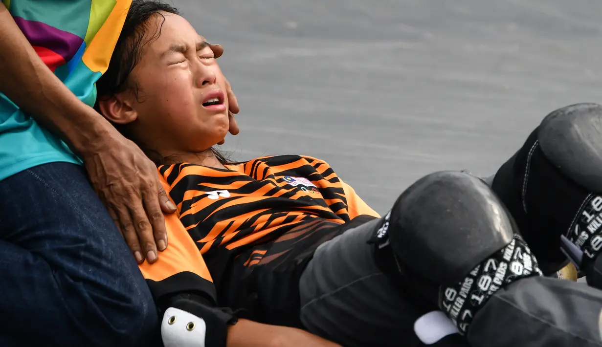 Tim medis melakukan pertolongan kepada skateboarder Malaysia Christina Grace Lai yang cedera saat melakukan pemanasan jelang final taman putri Asian Games 2018 di Palembang, Rabu (29/8). Atlet 13 tahun itu terjatuh saat  melakukan trik. (Mohd RASFAN/AFP)