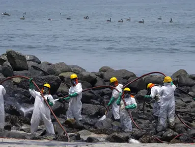 Pekerja melanjutkan kampanye pembersihan minyak di Pantai Pocitos, Ancon, Peru, 15 Februari 2022. Sebulan berlalu, pekerja melanjutkan pembersihan di pantai setelah terkontaminasi tumpahan minyak Repsol. (AP Photo/Martin Mejia)