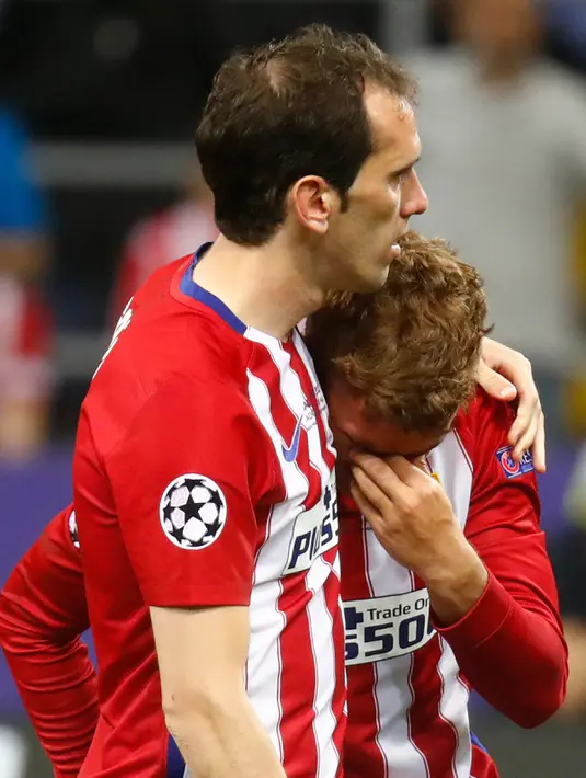 Diego Godin (kiri) dan Antoine Griezmann usai Final Liga Champions 2015/2016 di Stadion San Siro, Milan, Minggu (29/5). Atletico harus mengubur mimpi mereka usai kalah 5-3 lewat adu pinalti dengan Real Madrid. (Reuters / Carl Recine)