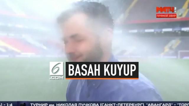 Seorang presenter olahraga basah kuyup setelah terkena semprotan air di stadion milik CSKA Moscow. Ia tetap menyampaikan berita secara tuntas tanpa meninggalkan satu kejanggalan.