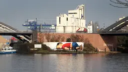 Sebuah grafiti raksasa bergambar balita Aylan Kurdi yang meninggal karena tenggelam, di dinding pinggiran sungai di Frankurt, Jerman, 10 Maret 2016. Gambar tersebut dibuat untuk menarik simpati pengendara, wisatawan dan dunia.  (Daniel ROLAND/AFP)