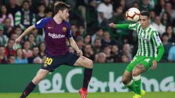 Pemain Real Betis, Tello Herrera, berebut bola dengan gelandang Barcelona, Sergi Roberto, pada laga La Liga 2019 di Stadion Benito Villamarin, Minggu (17/3). Barcelona menang 4-1 atas Real Betis. (AP/Miguel Morenatti)