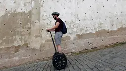 Seorang turis menggunakan segway di jalanan menurun di pusat kota Praha, Ceko, Selasa (19/7). Segway yang merupakan kendaraan personal listrik beroda 2 yang mampu menyeimbangkan sendiri itu kini menjadi favorit para turis. (REUTERS/David W Cerny)