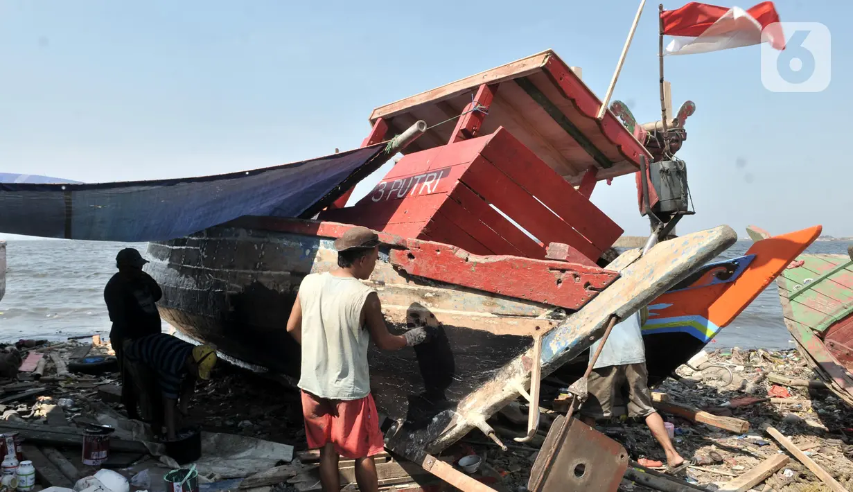 Pekerja menyelesaikan proses perbaikan kapal nelayan di pesisir Marunda, Jakarta, Selasa (22/10/2019). Jasa perbaikan kapal nelayan merupakan salah satu mata pencaharian utama warga pesisir Marunda selain mencari ikan di laut. (merdeka.com/Iqbal Nugroho)