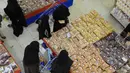 Warga Yaman membeli permen dan kacang-kacangan saat umat Islam bersiap untuk merayakan liburan tahunan Idul Adha (Hari Raya Kurban) di supermarket di ibu kota Sanaa (18/7/2021). (AFP/Mohammed Huwais)