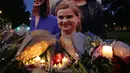 Karangan bunga dan lilin diletakkan di dekat foto anggota parlemen Inggris, Helen Joanne Cox, atau biasa dipanggil Jo Cox di alun-alun Parlemen, London, Kamis (16/6). Jo Cox tewas akibat ditembak seorang pria di jalan. (Daniel Leal-Olivas /AFP)