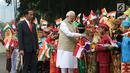 Perdana Menteri (PM) India, Narendra Modi didampingi Presiden Joko Widodo (Jokowi) bersalaman dengan murid Sekolah Dasar berpakaian adat Indonesia dalam upacara penyambutan di Istana Merdeka, Jakarta, Rabu (30/5). (Liputan6.com/Angga Yuniar)