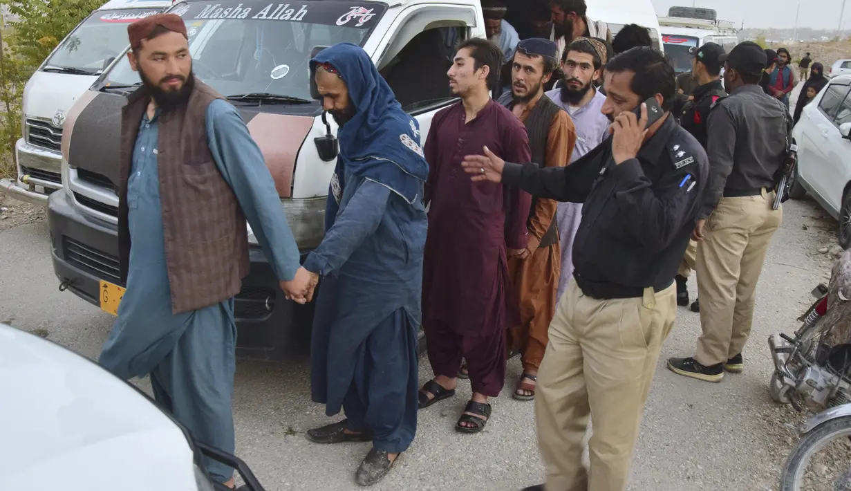 Polisi tiba bersama imigran Afghanistan yang ditahan di pusat deportasi, yang didirikan oleh pihak berwenang untuk memfasilitasi imigran ilegal, di Quetta, Pakistan, Rabu (1/11/2023). (AP Photo/Arshad Butt)