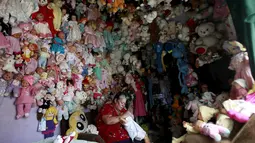 Adela Rojas saat memakaikan pakaian ke boneka miliknya di Heredia, Costa Rica (5/8/2015). Rojas telah mengumpulkan boneka selama lebih dari dua puluh tahun dan sekarang memiliki lebih dari 4.500 boneka. (REUTERS/Juan Carlos Ulate)