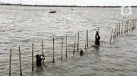 Pembongkaran dilakukan secara manual atau satu persatu, yakni dengan menarik pagar bambu dengan menggunakan tali yang terikat di perahu. (Magang/Liputan6.com/Muhammad Rizal)