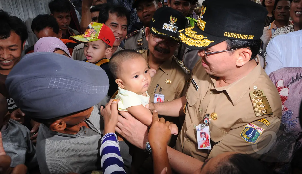 Gubernur DKI Jakarta Basuki T Purnama menggendong seorang anak balita di Tanah Abang, Jakarta. (Liputan6.com/Herman Zakharia)