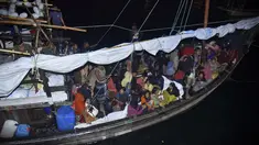 Pengungsi Rohingya duduk di perahu saat tiba di Pelabuhan Krueng Geukueh di Aceh Utara, Jumat pagi (31/12/2021). Sedikitnya 120 orang etnis Rohingya yang sempat terombang-ambing di lautan selama beberapa hari akhirnya dievakuasi ke daratan Aceh. (AP Photo/Rahmat Mirza)