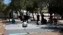Sejumlah imigran khusyuk melaksanakan salat pada hari pertama Ramadan, di sebuah kamp pengungsian milik pemerintah Yunani di Schisto, Athena, Senin (6/6). Para imigran itu membuat masjid darurat di sebuah halaman terbuka. (REUTERS/Alkis Konstantinidis)