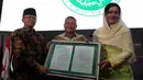 Dirut PT Kustodian Sentral Efek Indonesia (KSEI), Friderica Widyasari Dewi menerima salinan fatwa secara simbolis dari Sekretaris DSN-MUI, Anwar Abbas di Gedung BEI, Senin (1/4). KSEI secara resmi memperoleh fatwa dari DSN-MUI terkait Proses Bisnis Atas Layanan Jasa (Liputan6.com/Johan Tallo)