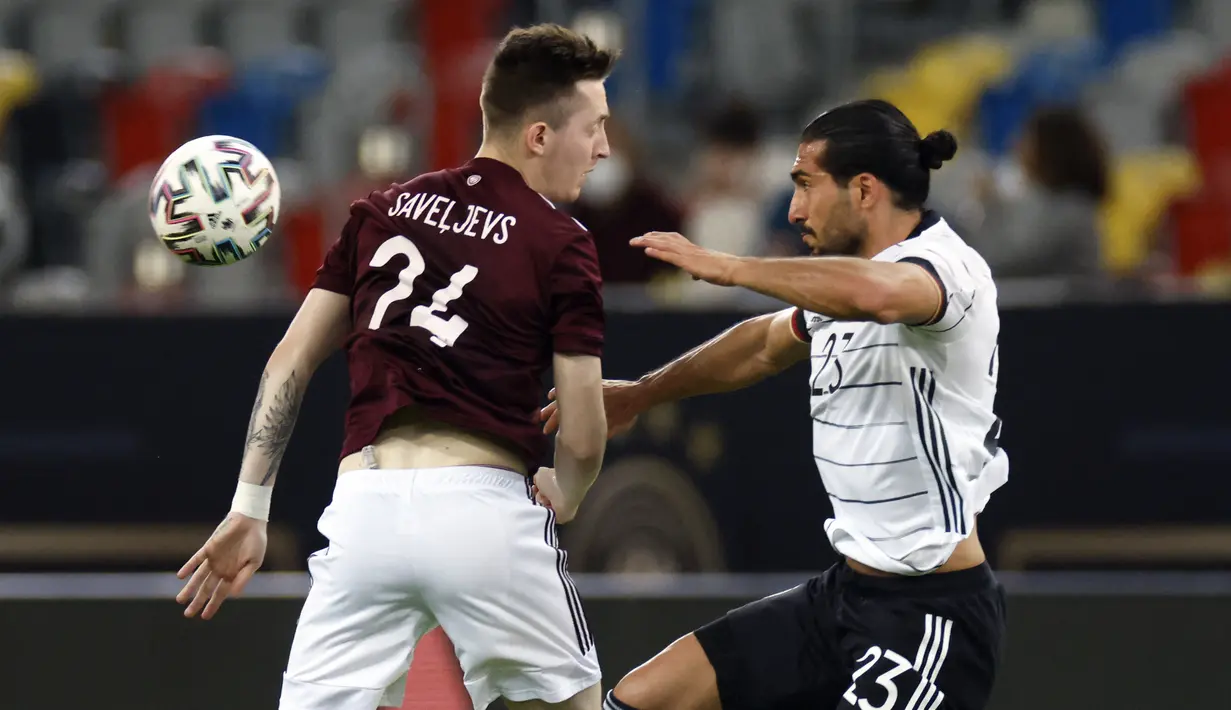 Gelandang timnas Jerman, Emre Can (kanan) berebut bola dengan gelandang Latvia, Aleksejs Saveljevs dalam laga uji coba jelang EURO 2020 di Merkur Spiel Arena, Selasa (8/6/2021) dini hari WIB. Timnas Jerman memenangkan pertandingan dengan skor 7-1 atas timnas Latvia. (Odd ANDERSEN / AFP)